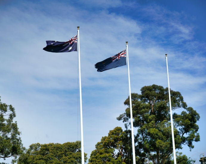 three flags flying in the wind on a sunny day