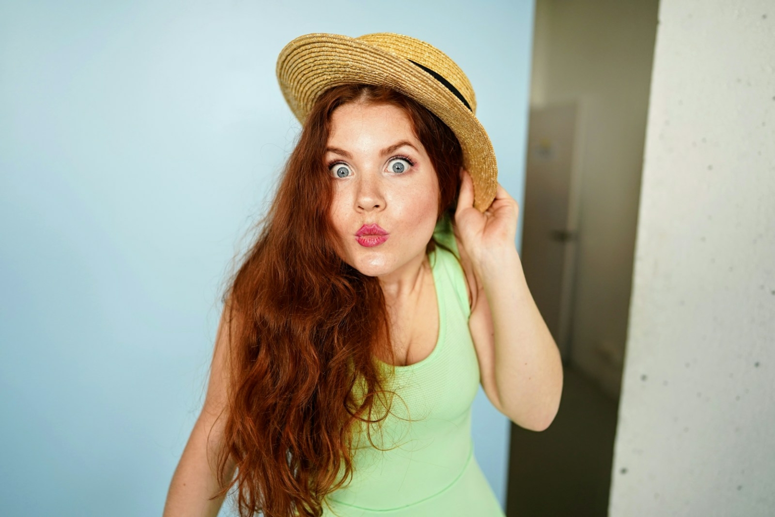 woman holding brown straw hat