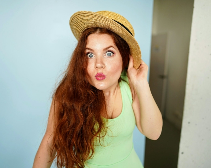 woman holding brown straw hat