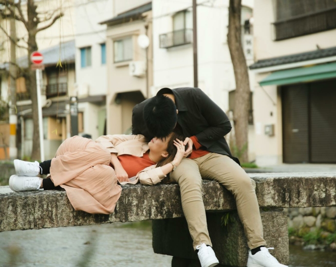 Lovely couple in casual clothes resting on concrete bridge during enjoying time together