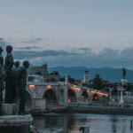 a group of statues by a river