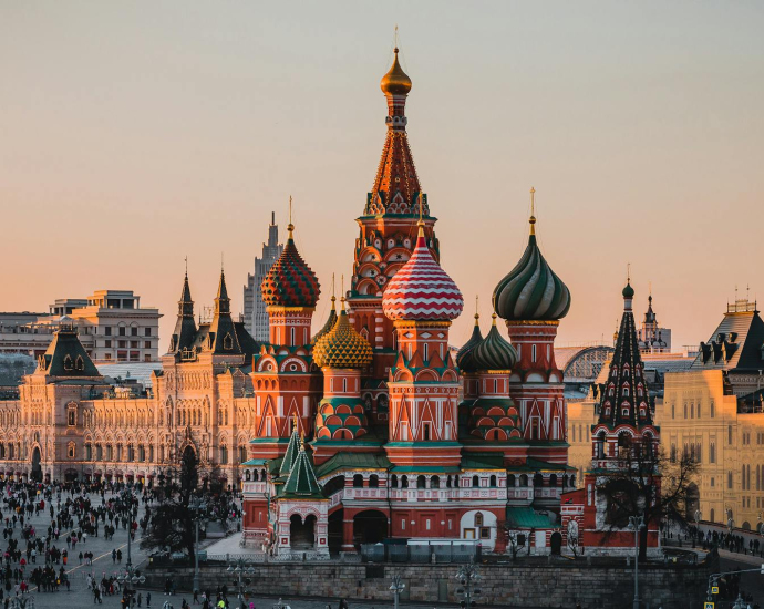 Stunning view of St. Basil's Cathedral in Moscow during sunset with a bustling crowd.