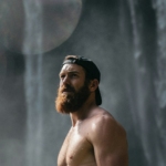 topless man wearing black fitted cap