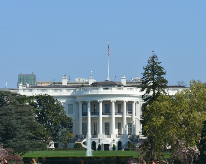 white concrete building near green trees under blue sky during daytime