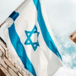 an israeli and israeli flag hanging from a brick building