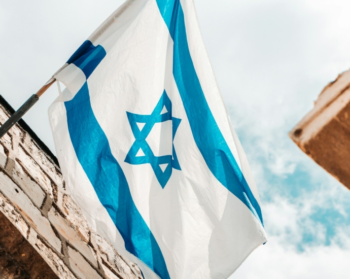 an israeli and israeli flag hanging from a brick building