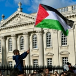 a young boy holding a flag in front of a building