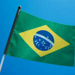 the flag of brazil is flying in the blue sky