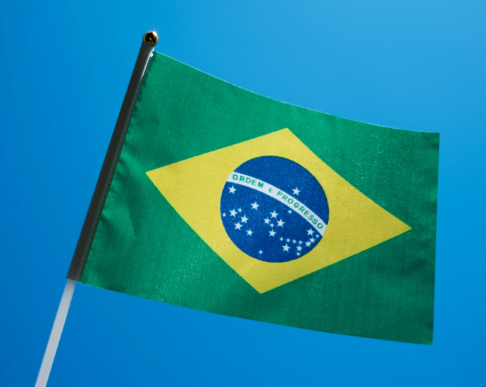 the flag of brazil is flying in the blue sky