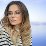 woman wearing black and white striped top and round eyeglasses