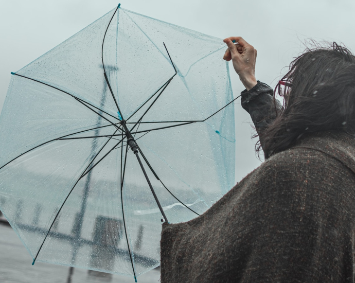 woman in black jacket holding umbrella