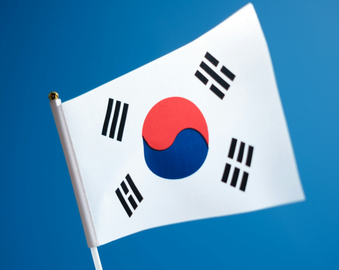 a korean flag flying in the wind with a blue sky in the background