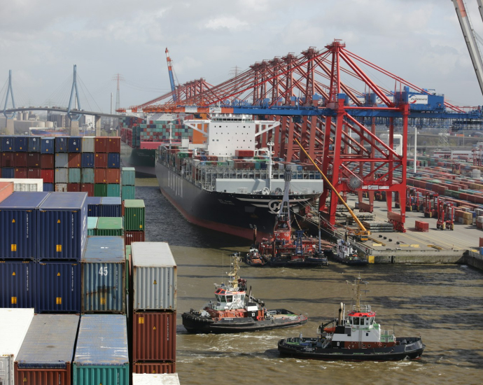 a tug boat in the water next to a large cargo ship