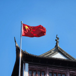 A chinese flag flying on top of a building