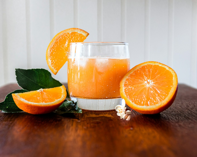 a glass of orange juice on a wooden table