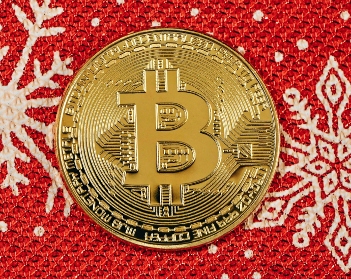 a bit coin sitting on top of a red and white blanket