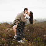 a man and a woman kissing in a field