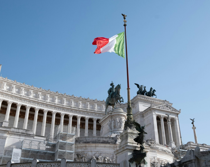 a flag flying in the wind in front of a building