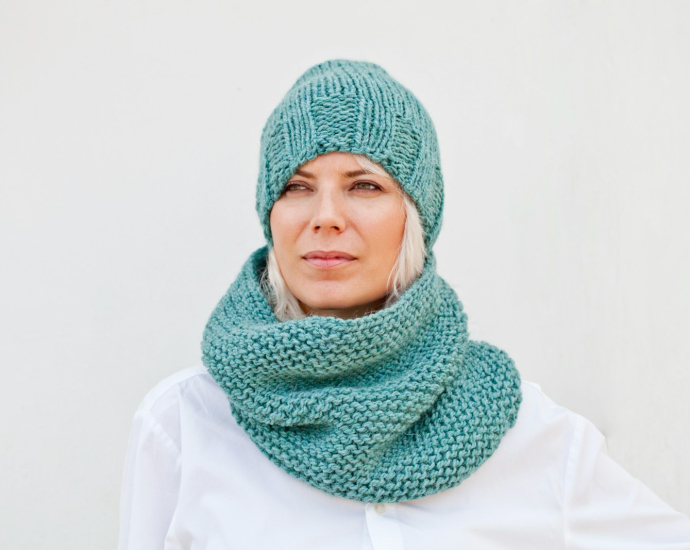 A woman wearing a scarf and a knitted hat