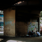 a group of people sitting on the side of a building