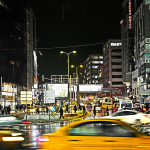 cars on road between buildings during night time