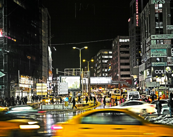 cars on road between buildings during night time