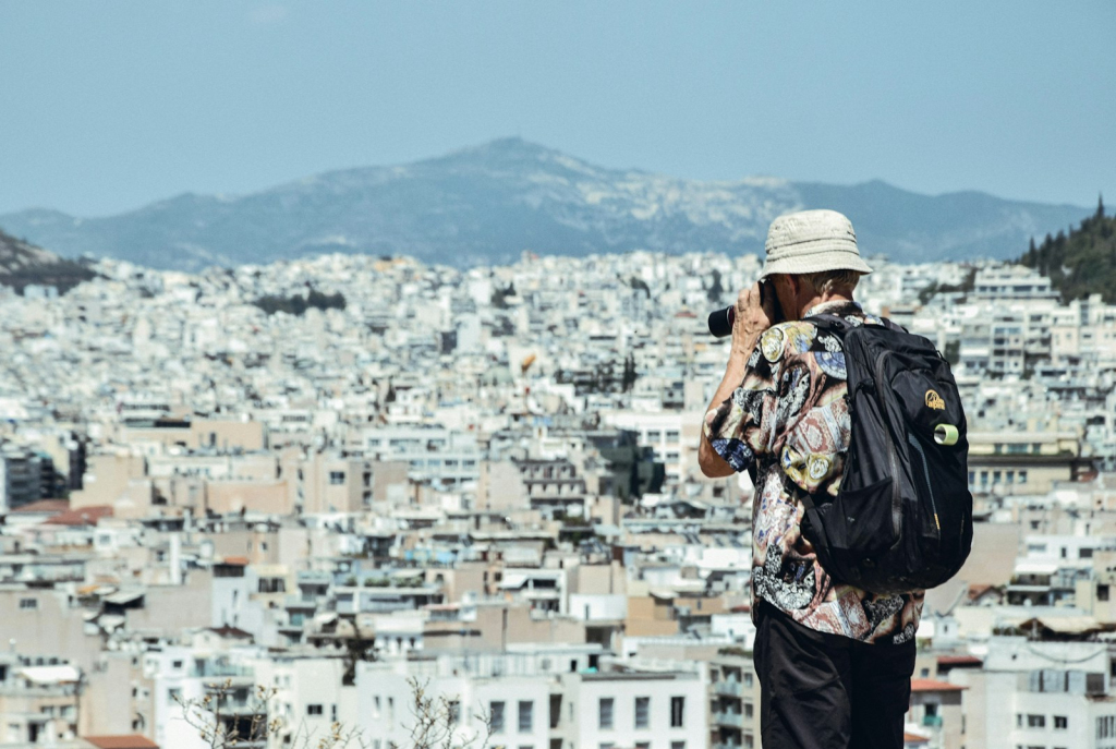 a man standing on top of a hill talking on a cell phone