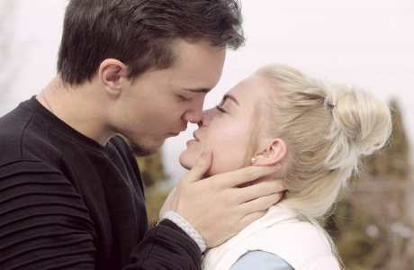 man wearing black top about to kiss woman