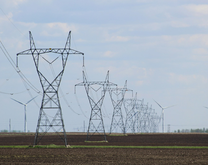 transmission towers and wind turbines on the field