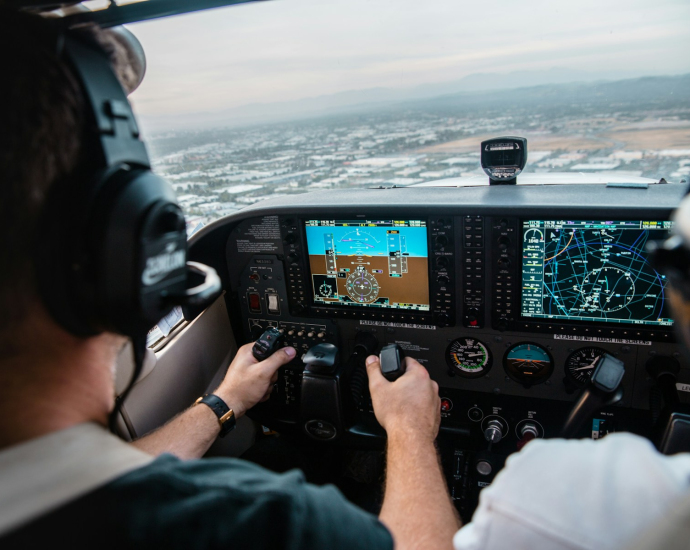 man flying aircraft under cloudy sky