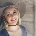 Smiling blonde woman wearing a hat.