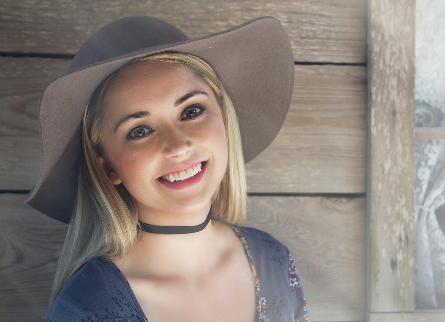 Smiling blonde woman wearing a hat.