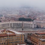 Stunning aerial view of St. Peter's Square enveloped in fog, showcasing Roman architecture.