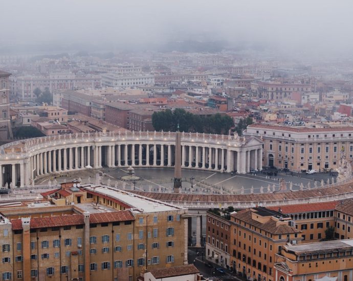 Stunning aerial view of St. Peter's Square enveloped in fog, showcasing Roman architecture.
