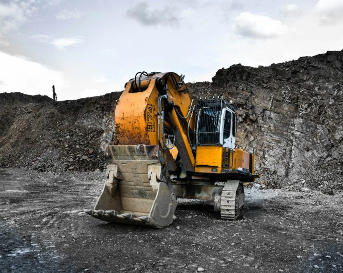 yellow and black excavator near hill