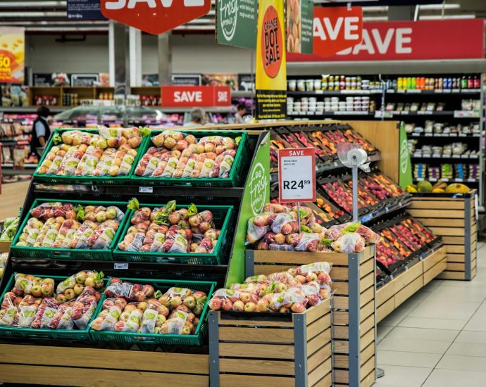 Colorful produce aisle in a supermarket showcasing fresh apples with discount signage.