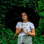 woman posing under black umbrella