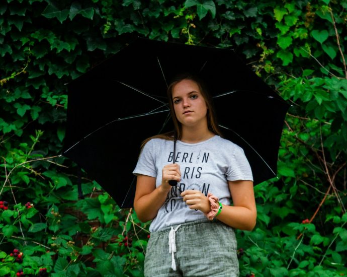 woman posing under black umbrella