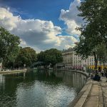 people walking on sidewalk near river during daytime