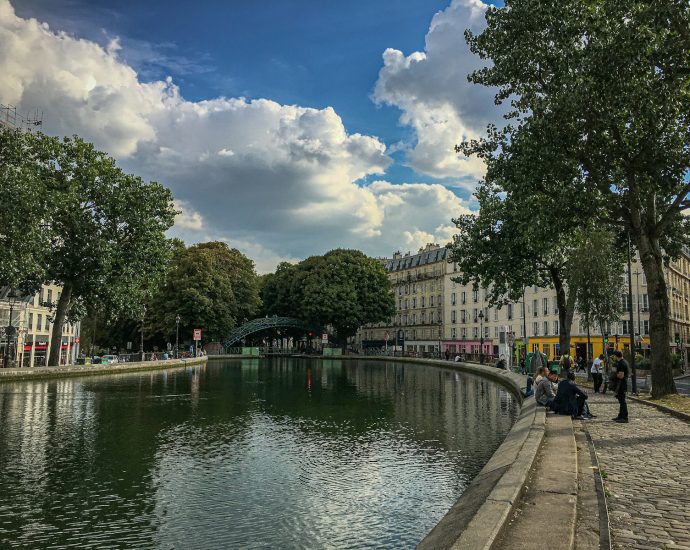 people walking on sidewalk near river during daytime