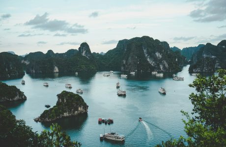 high-angle photography of boats on water near hill during daytime