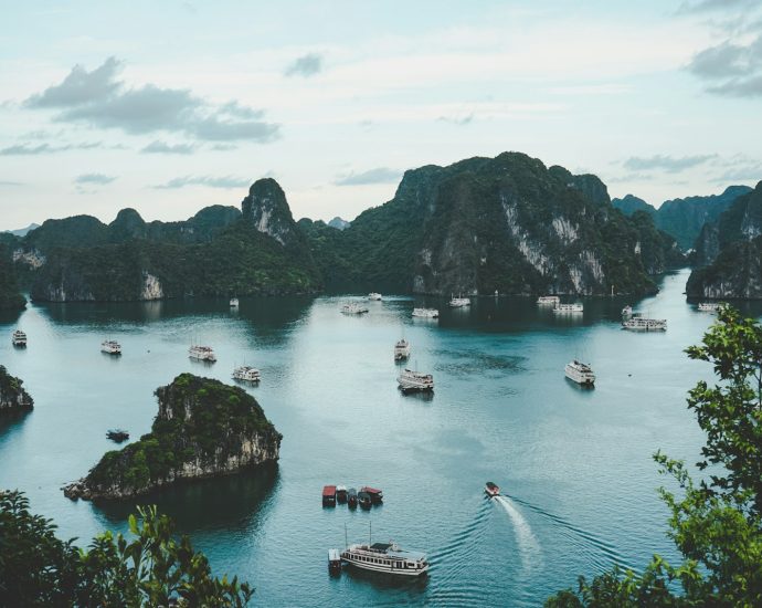 high-angle photography of boats on water near hill during daytime
