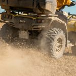 yellow and black front loader on beach during daytime