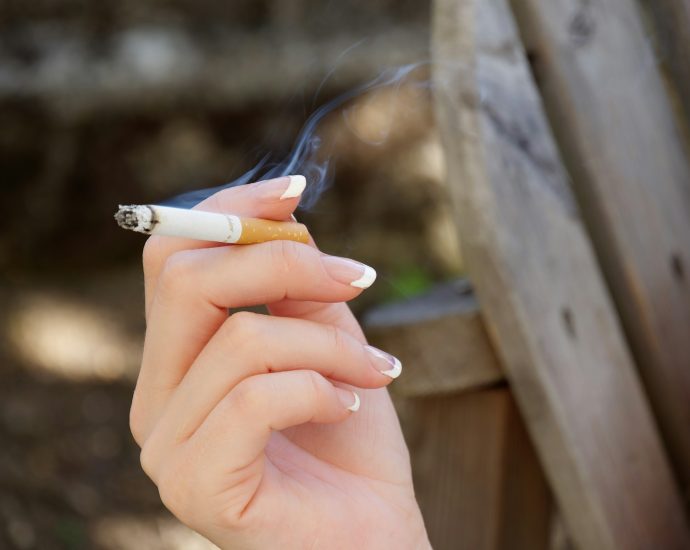 person holding white and blue toothbrush