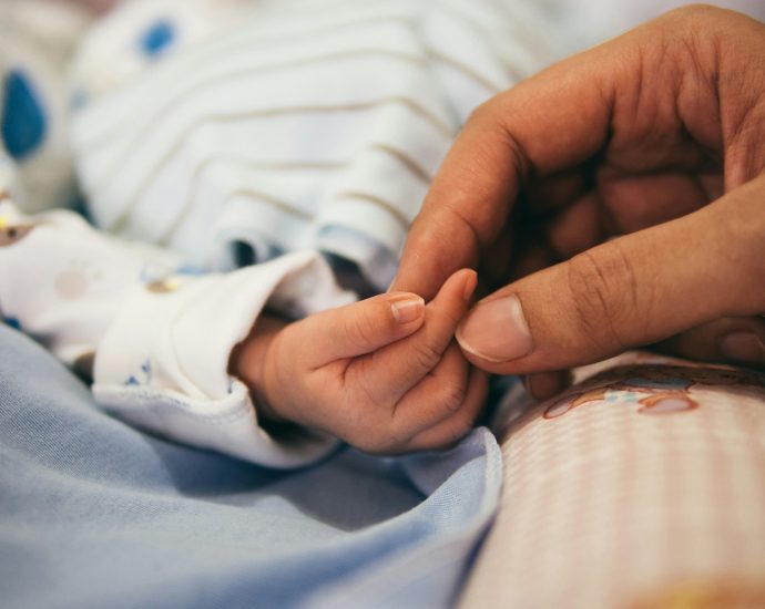 person holding baby's index finger