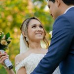 a bride and groom holding a bouquet of flowers