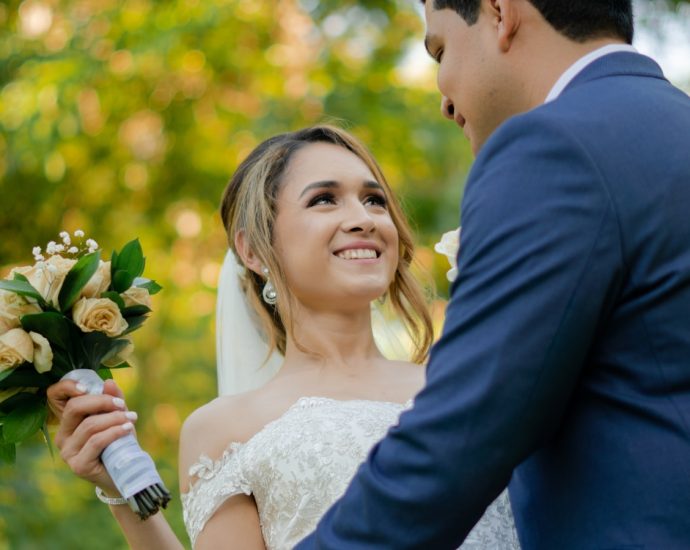 a bride and groom holding a bouquet of flowers
