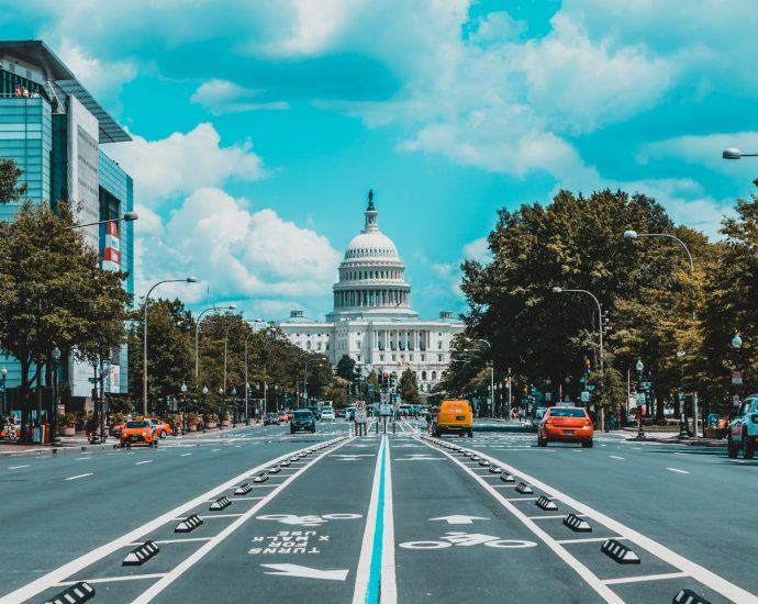 wide road with vehicle traveling with white dome building