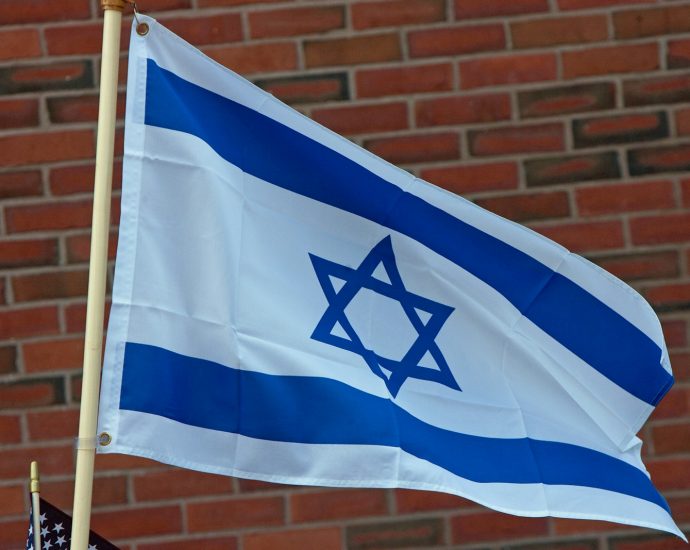 A flag flying in front of a brick building