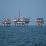 a group of oil rigs sitting on top of a large body of water
